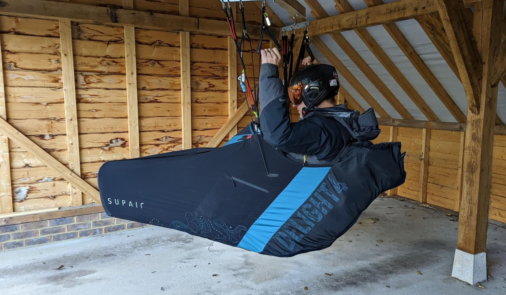 Pilot in a pod harness in the Precision Repack harness hanger simulator